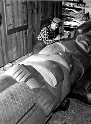 Mungo Martin sculptant une reproduction d'un mât mortuaire haida pour le parc Thunderbird 