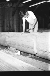 Richard Hunt sculptant un mât totémique à l'aide d'une masse et d'un burin