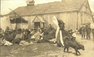 Distribution d'étoffes au cours d'un potlatch à la mémoire d'Ida Jackson dans l'Ancienne Réserve songhees en 1908. 