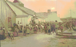 Distribution de biens au cours d'un potlatch à la mémoire d'Ida Jackson dans l'Ancienne Réserve songhees en 1908. 