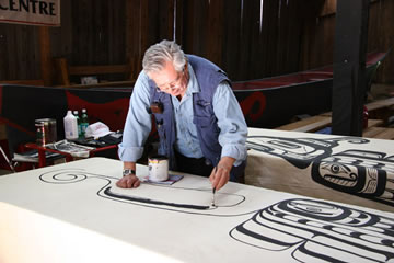 Le chef Tony Hunt peignant un nouveau motif pour un rideau de danse de Wawadiťła, exhibé pour la première fois lors de l’inauguration du site web du parc Thunderbird le 18 mai 2006. 
