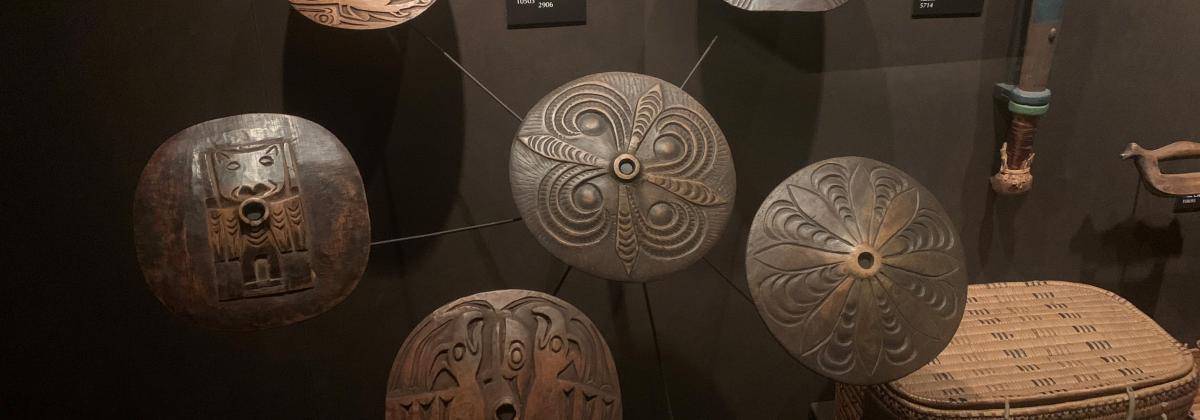 An exhibit showing seven different spindle whorls created by Indigenous artists.
