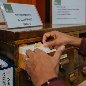 hands flipping through index cards at the archives