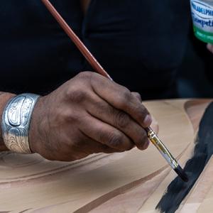 Hand painting a wood carving
